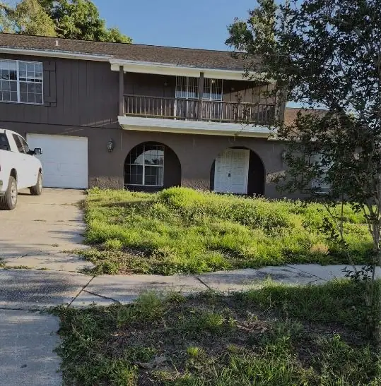Before: an overgrown front lawn cut, edged and cleared, a LoLo Lawncare job in the Tampa area