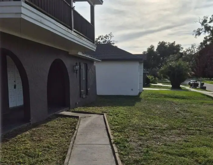 After: a buried front walk edged back to the concrete, a LoLo Lawncare job in the Tampa area