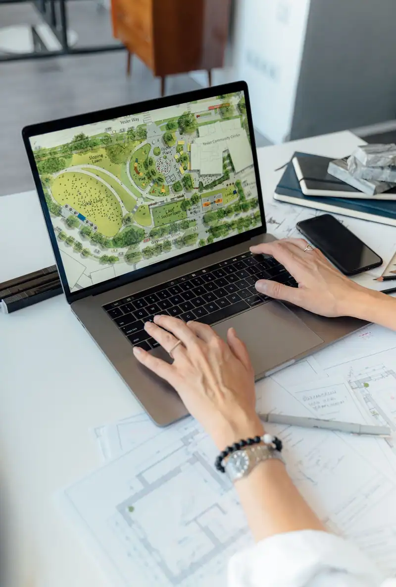 Hands working on a landscape plan on a laptop
