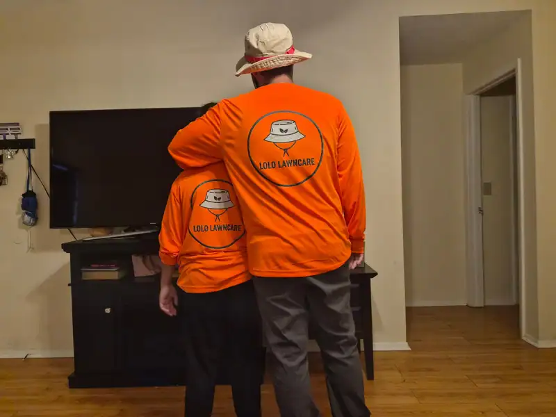 Two LoLo Lawncare team shirts with the bucket-hat logo on the back